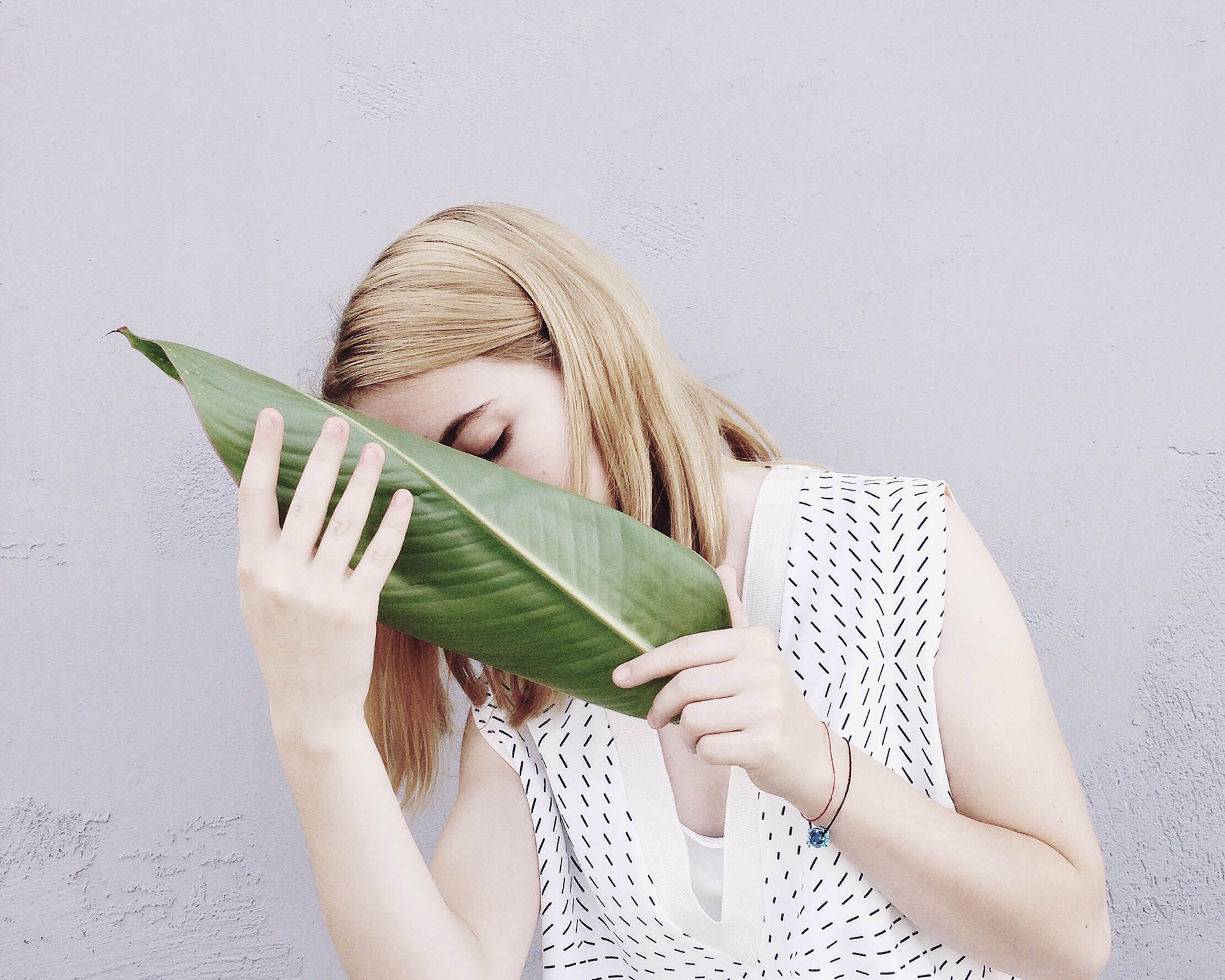 A woman hiding her face with a leaf